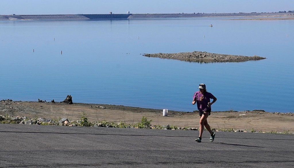 A jogger runs up a boat ramp that is normally underwater in Folsom, Calif., on Oct. 3, 2022. Widespread drought in large parts of Europe, the United States and China this past summer was made 20 times more likely by climate change, a new study shows. (AP)